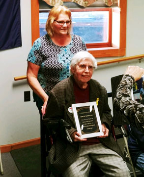 woman in wheelchair holding large plaque