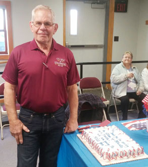 man standing next to cake