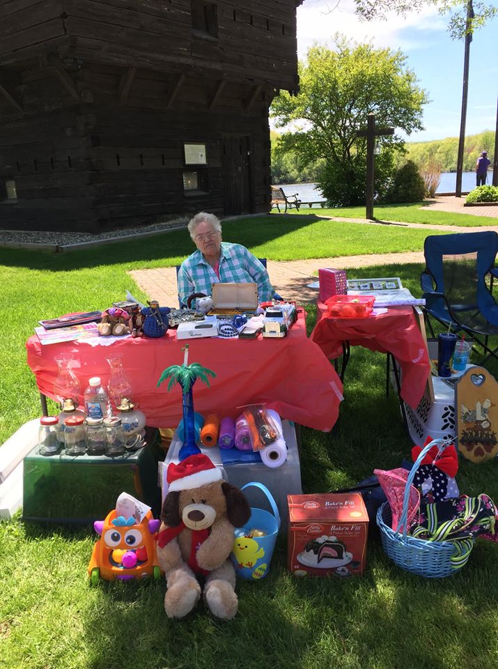 man sit at garage sale table