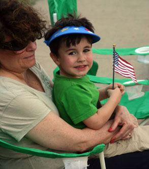 little boy wave American flag in woman's arms