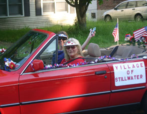 woman waves from red convertible