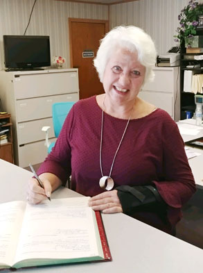 gray hair woman sign a book