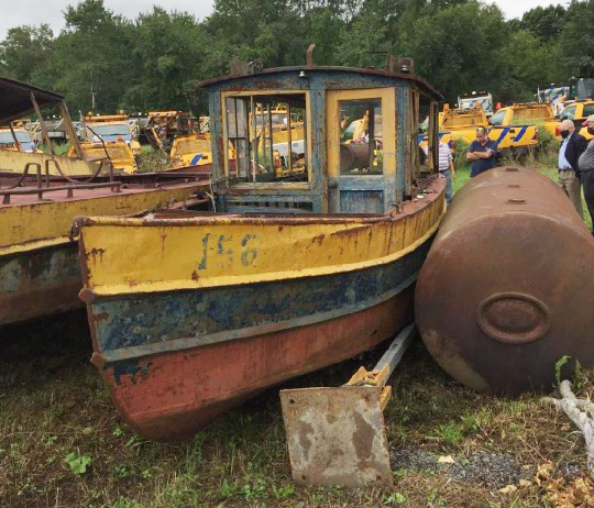 old yellow boat docked in a scrap yard