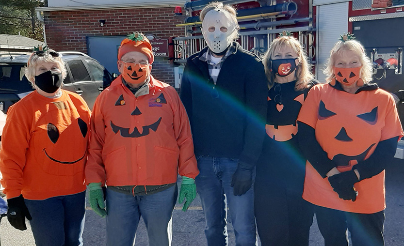 five village trustees dressed as pumpkins for Halloween